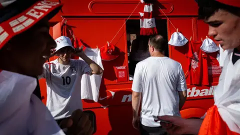 Getty Images England fans collect merchandise before the highly anticipated World Cup semi-final.